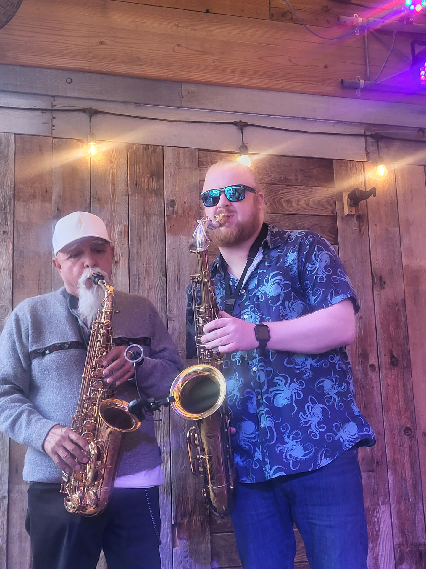 Raul performing saxophone with a fellow musician