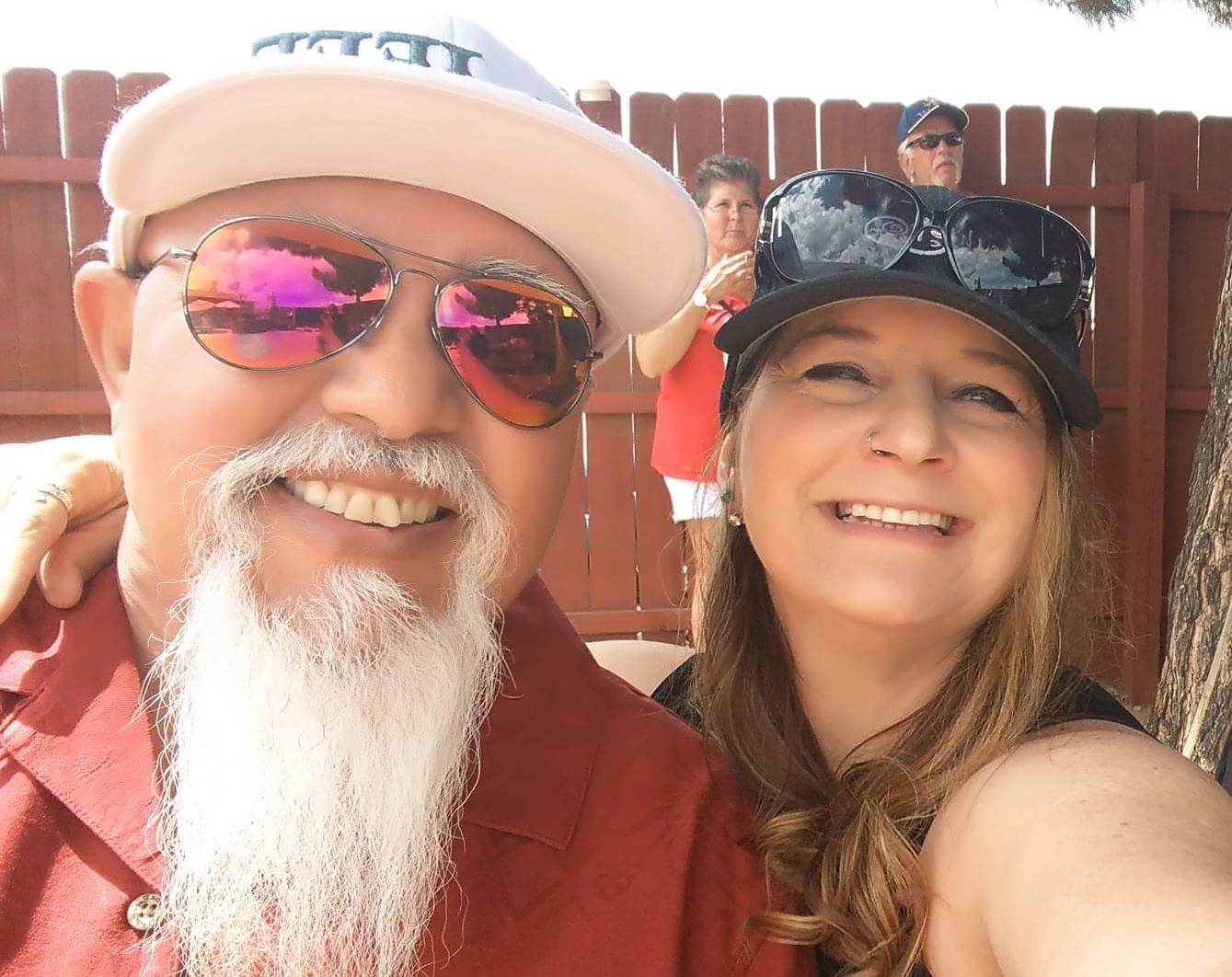 Laurie and Raul smiling outdoors on a sunny afternoon