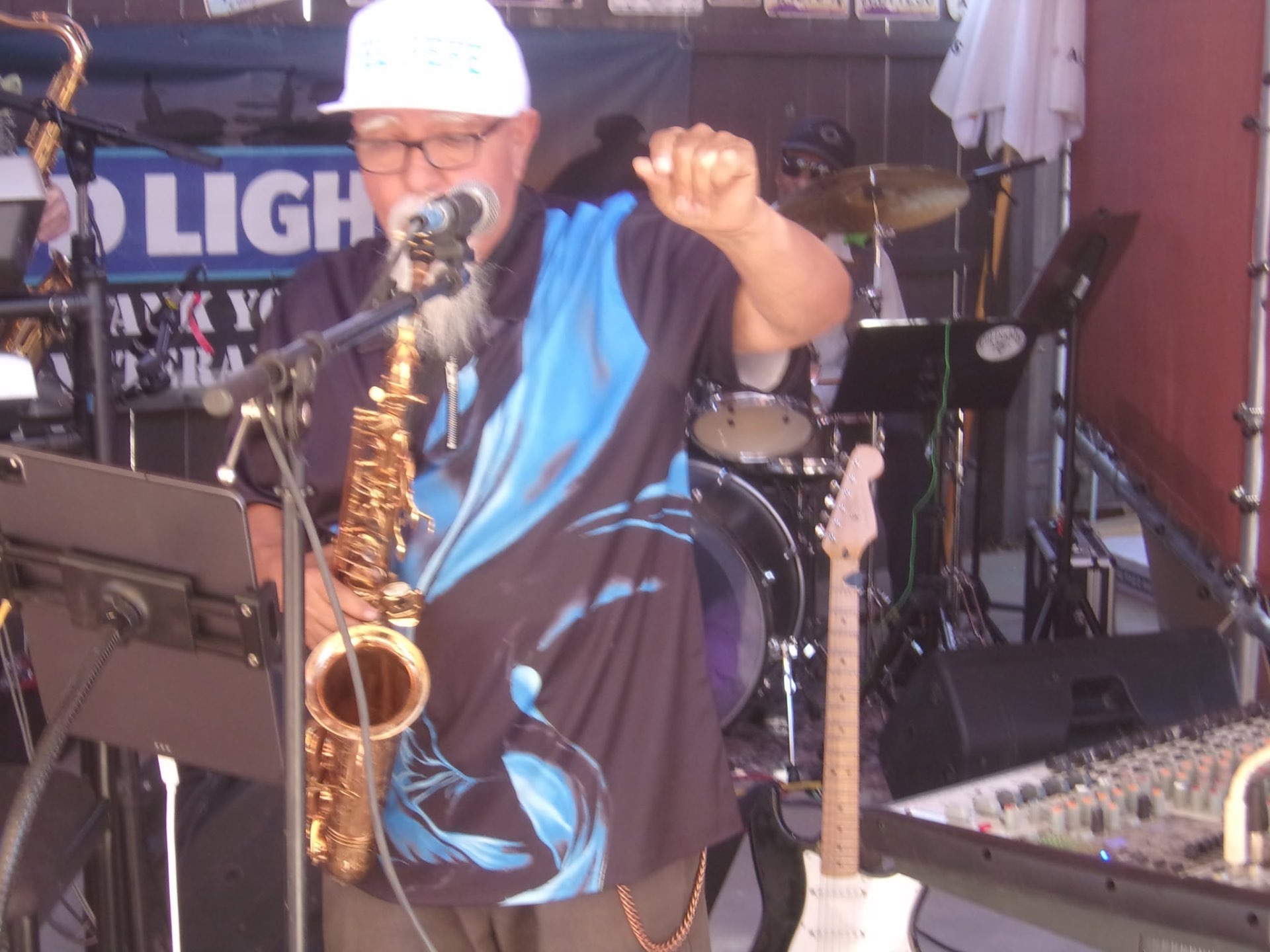 Raul playing saxophone into the microphone during a live performance